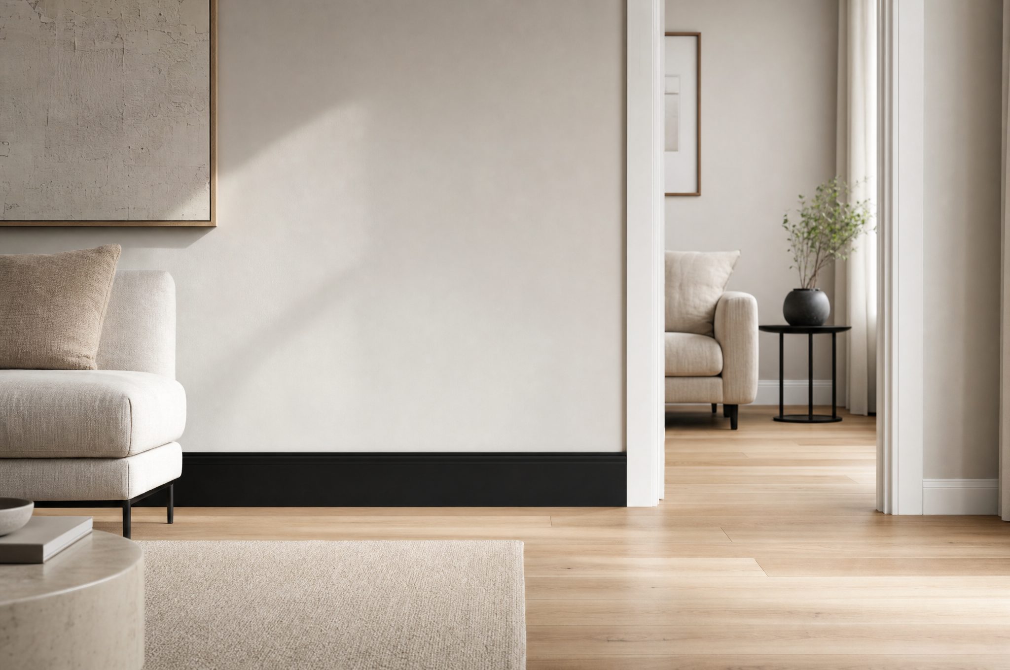 Jasny salon z białą listwą przypodłogową między szarą ścianą a podłogą z jasnego dębu